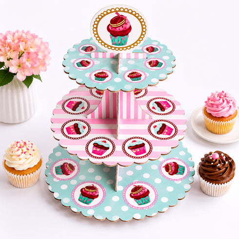 Three-tiered cupcake stand with polka dot and striped design, surrounded by cupcakes on a white background.